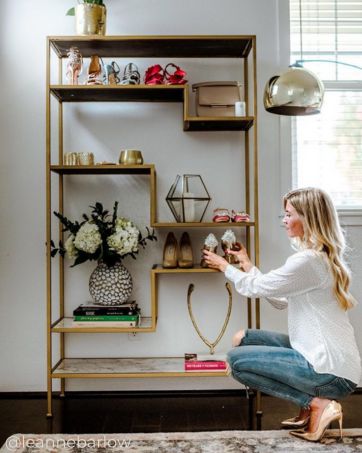 a gold and faux marble shelving unit brings storage organization and style to this room